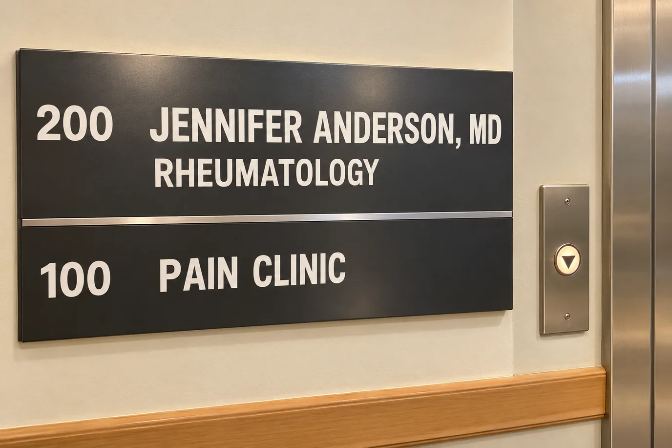 The directory sign by the elevator in her building: 200 Jennifer Anderson, MD, Rheumatology, and 100 Pain Clinic, with the elevator's down button lit